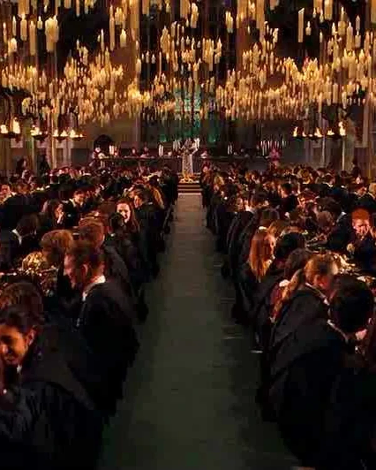 The Great Hall at a feast, long tables beneath floating candles