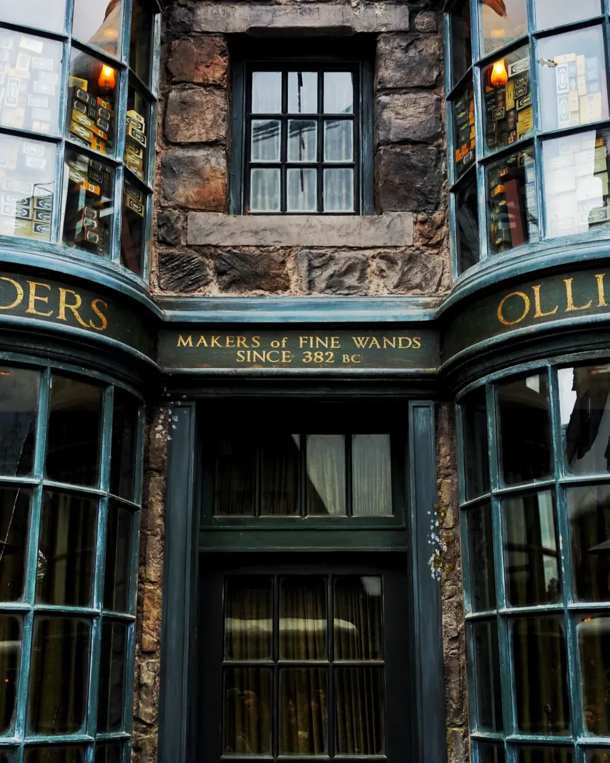 A wand shop front with bow windows and a hand-painted sign