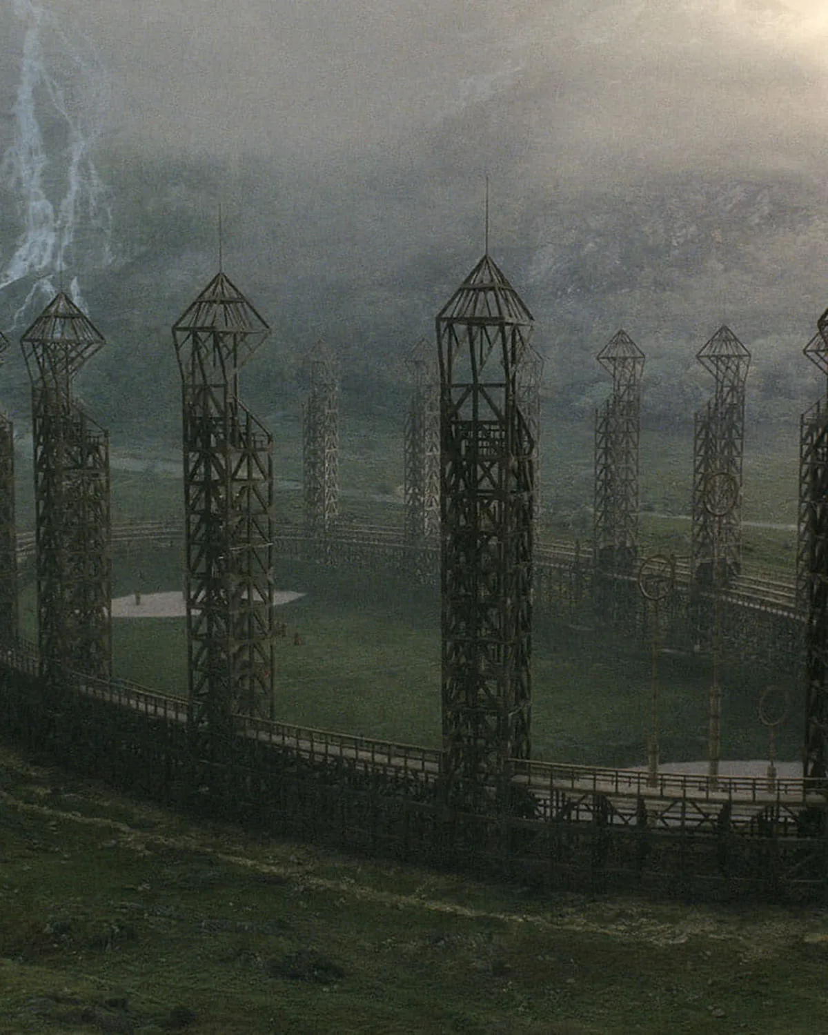 The Quidditch pitch, tall goal towers under a grey sky