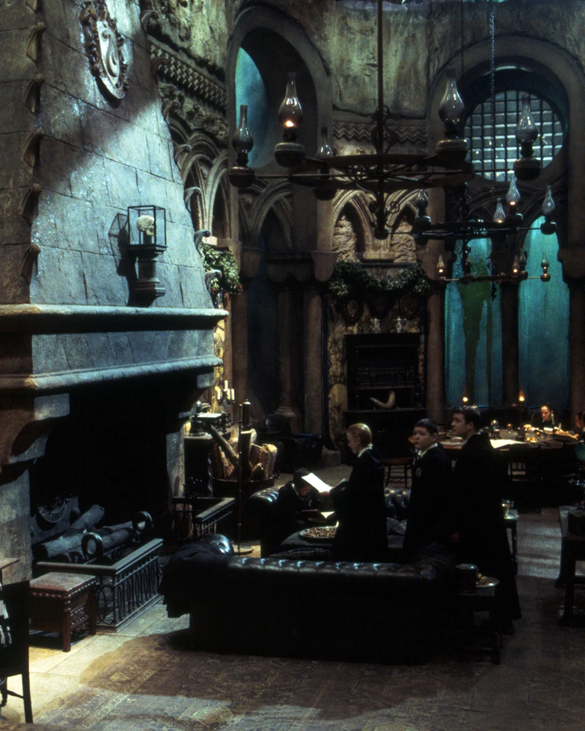 The Slytherin common room under the lake, green light and stone arches